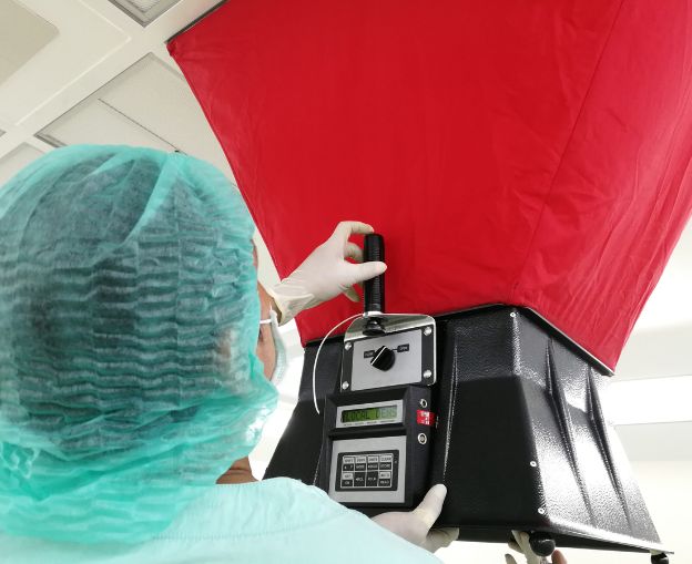 Technician conducting HVAC performance testing with a blower door and measurement equipment.
