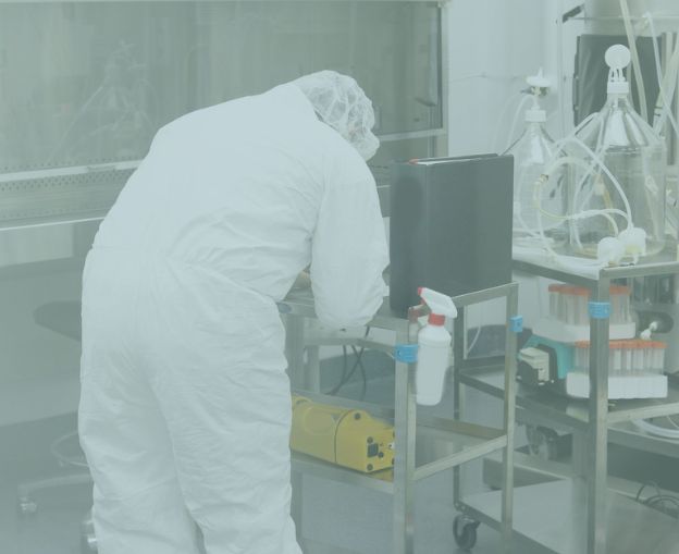 Scientist in protective gear conducting remote surface sampling in a lab environment